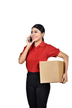 Portrait of asian female courier with cell phone carrying boxes standing isolated over white background