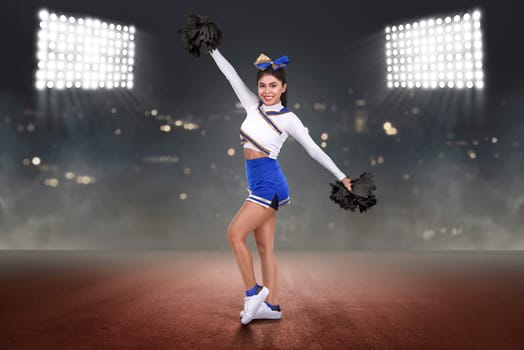 Happy asian cheerleader performing with poms on the stadium