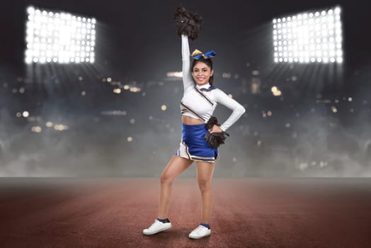 Young asian cheerleader action with pom-poms on the stadium