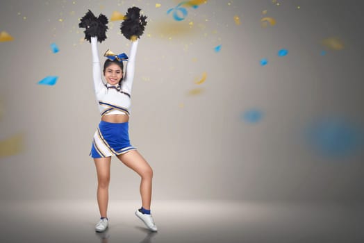 Beautiful asian cheerleader action with pom-poms over confetti background
