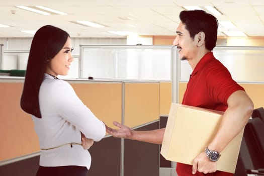 Handsome asian courier man deliver the package to businesswoman at office