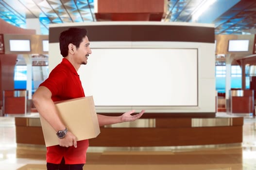 Side view of asian delivery man send a parcel on the building