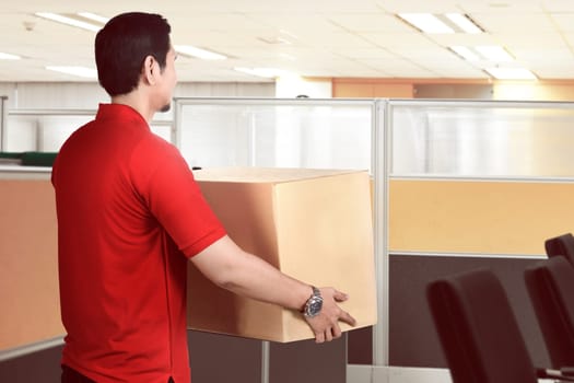 Rear view of asian delivery man deliver the package to office