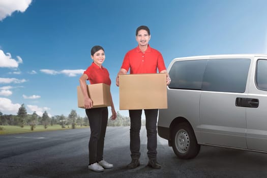 Happy asian courier team deliver the package to people with van on the background