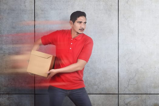 Attractive asian male courier bring the box with wall background