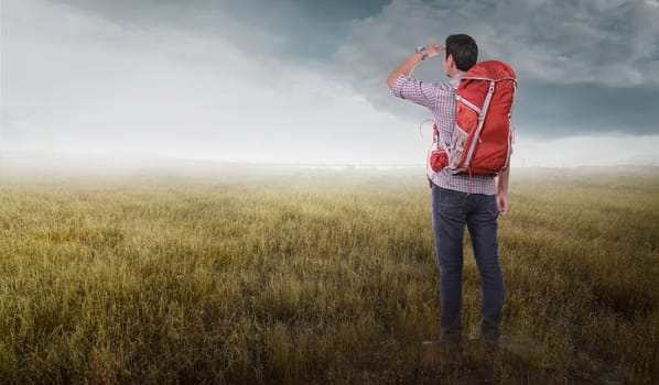 Attractive asian traveler man with backpack looking at landscapes on meadow field
