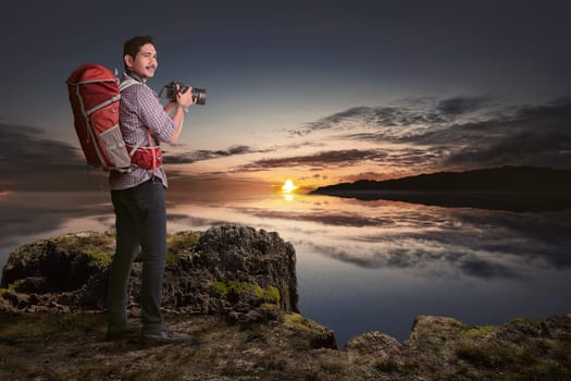 Attractive asian traveler man with camera want to taking a photos at sunset