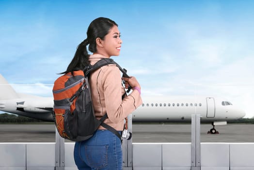 Pretty asian tourist going traveling by plane on the airport