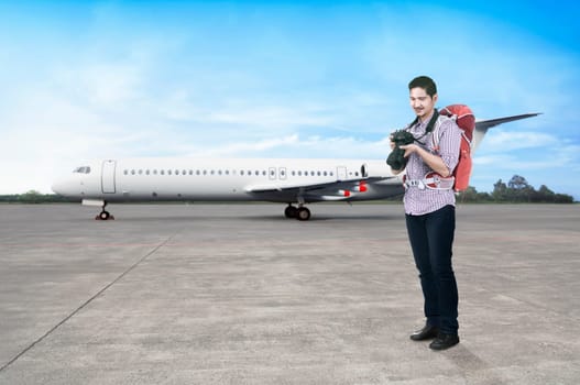 Young asian man with backpack and camera going traveling by airplane
