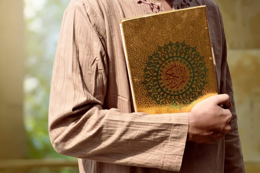 Muslim man holding Quran on the mosque
