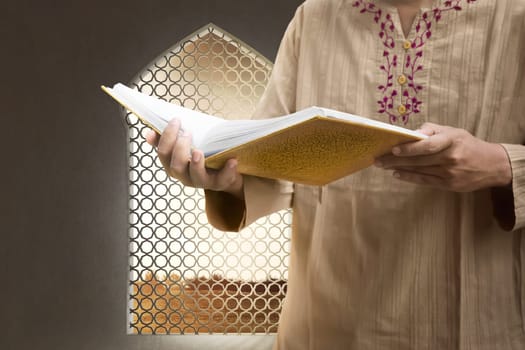 Muslim man reading the Koran on the mosque