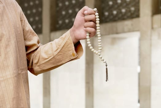Muslim man praying with prayer beads in the mosque