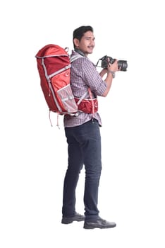 Attractive asian traveler with backpack and camera posing isolated over white background.