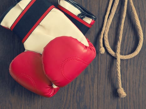 Red boxing gloves on a rustic wooden wall, sports or assertiveness concept