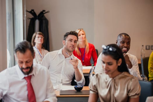 Front view of a group of business people looking forward and listening during a business conference.