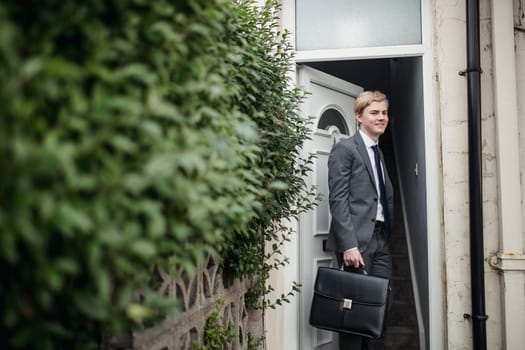 Young businessman leaving the house to commute to work.