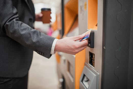 Unrecognisable person paying for a train ticket with contactless payment at a ticket machine.