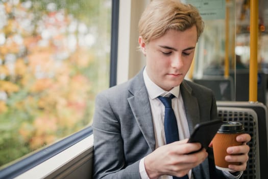 Young businessman using his smart phone while on his commute to work on the train.