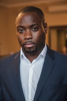 Front view of a young businessman looking at the camera with a serious facial expression.