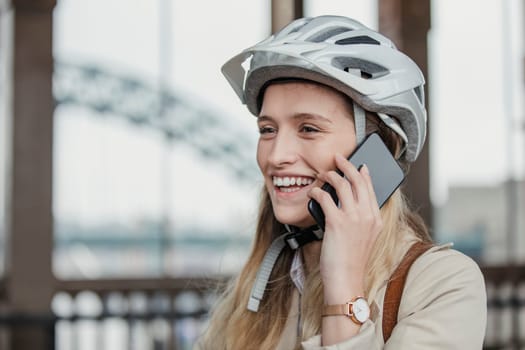 Side view of a smiling businesswoman making a phone call while while cycling to work.