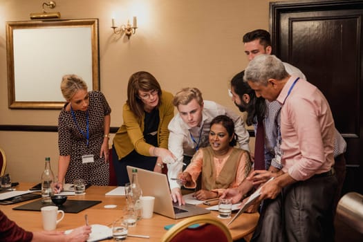 Medium sized group of business people working late and together to get work finished.