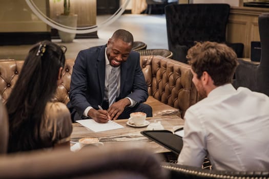 Rear view of three business people having a meeting in the reception of a building.