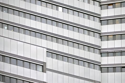 The modern façade of an office building with rows of windows.