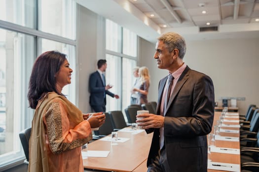 Business man and business woman talking before the meeting starts. Being friendly and talking, getting to know each other.