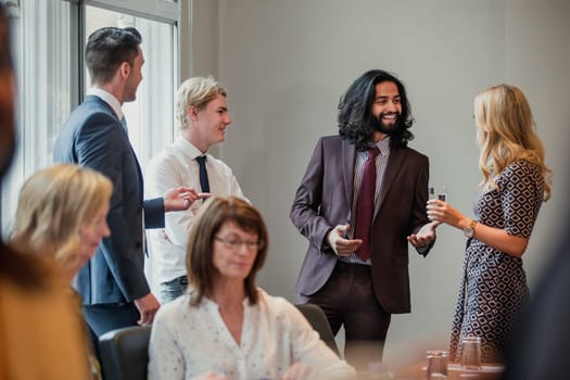 Businessmen and women meeting and greeting each other at a business meeting.
