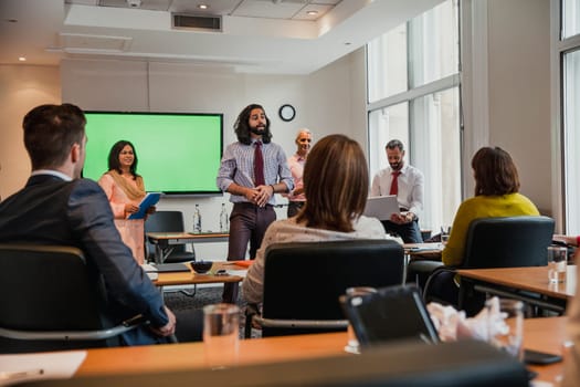 Group of business men and women giving a presentation to another small group of business men and women.