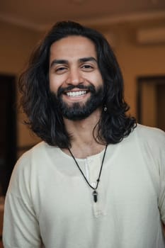 Close-up, front view headshot of a young male adult smiling at the camera.