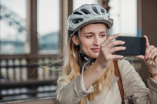 Young female adult stopping to take a photo while cycling to work.