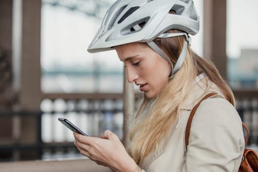 Side view of a businesswoman using her mobile phone on her morning cycle to work.