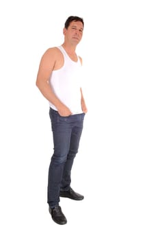 A handsome tall middle age man standing with his hands in his pocket.in jeans and white undershirt, isolated for white background.