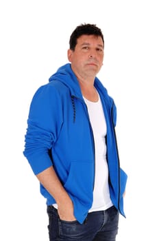 A tall handsome man standing in a blue hoody with his hands in his.pocket, isolated for white background.