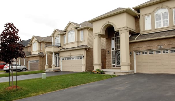 Some new big houses in a suburban subdivision in Canada in a.residential area.