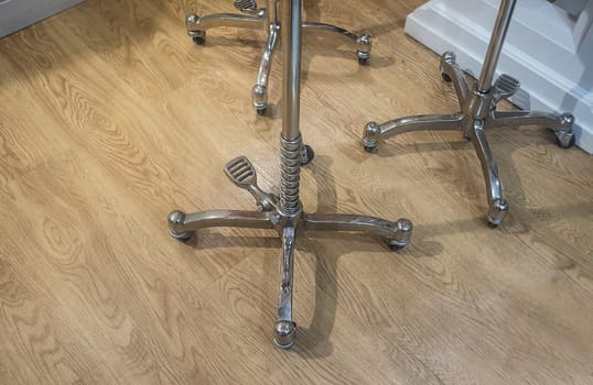 Wheeled traditional style dressmakers for mannequins over wooden floor. Closeup