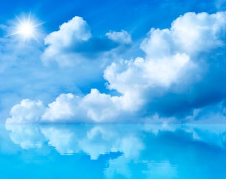 Summer background with blue sky and white clouds. Blue sunny sky above the water. Clouds and the sun are reflected in the water.