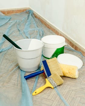 Painter paints the wall with the tint of white. Wall with serious moisture problems. Detail of the brush. white dye is prepared for the painter's job.