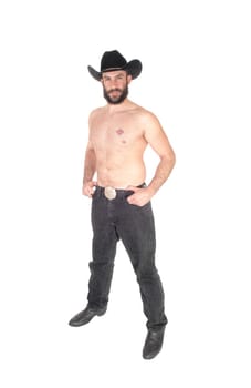 Handsome man standing shirtless, wearing a black cowboy hat and .jeans with his beard, isolated for white background.