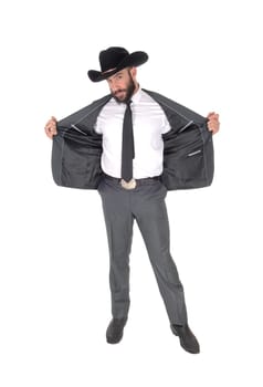 A handsome man standing in a gray suit and cowboy hat opens his.jacket, with beard and mustache, isolated for white background.
