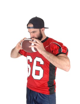 A close up image of a football player in his jersey, holding his football.to his mouth, thinking, isolated for white background.
