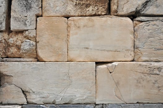 Acropolis of Athens textured wall background cracked marble blocks with ancient faded inscription.