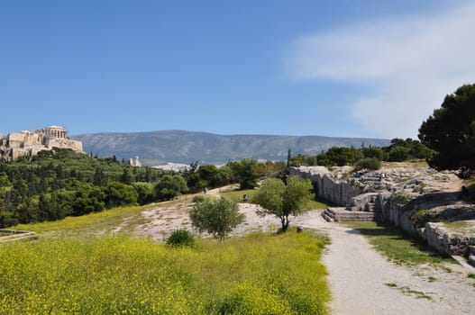 ATHENS, GREECE - APRIL 20, 2014: Pnyx monument speaker's platform and rock carved steps ancient democratic assembly of Athenian citizens with view to the Acropolis. Athens in springtime.