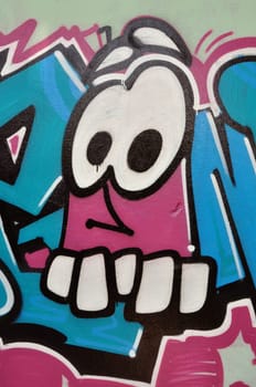ATHENS, GREECE - JULY 25, 2014: Funny cartoon caricature face spray painted on a wall covered with graffiti. Urban street art.