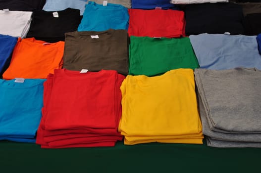 Cotton short sleeve t-shirts folded colorful clothes background.