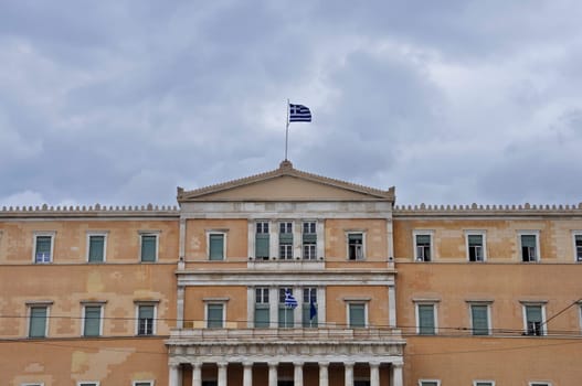 Hellenic parliament neoclassical building facade under cloudy sky. Athens, Greece.