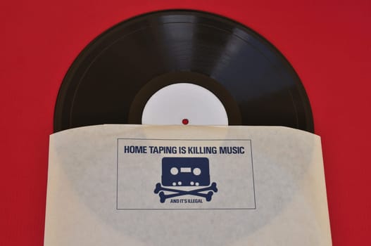 ATHENS, GREECE - AUGUST 1, 2014: Vinyl record inner sleeve with 1980s anti copyright infringement campaign skull and crossbones with cassette tape head. Home taping music piracy.