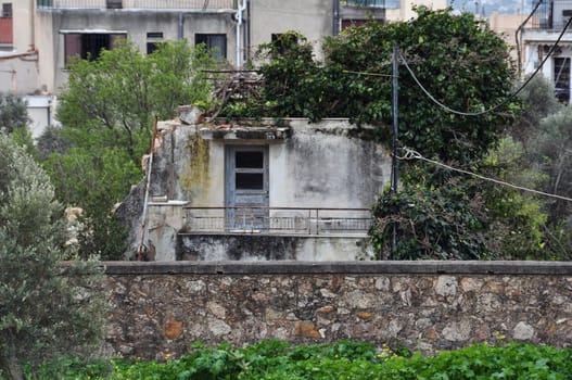 Old abandoned house reclaimed by nature. Urban ruin and overgrown plant.