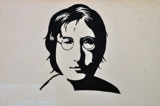ATHENS, GREECE - AUGUST 30, 2014: John Lennon portrait stencil graffiti urban art on textured wall.